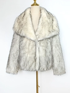 Détail du grand col à revers et de la texture en fausse fourrure douce du manteau gris