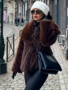 Detail of a plush faux fur headband and matching deep brown winter coat in a city street