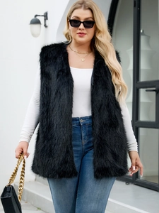 Street style shot of a long black faux fox fur vest with a fluffy texture and V-neckline