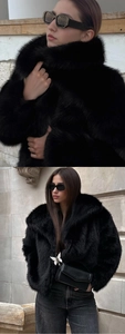 Detail of black faux fur coat with oversized lapel and silver butterfly bag accent