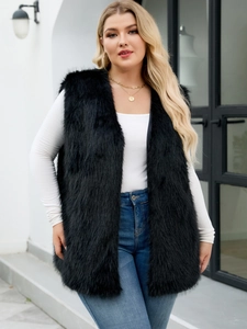 Close-up of black faux fur vest paired with white knitwear and gold necklace