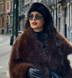 Detailed texture of brown faux fur winter headband and matching warm coat for women