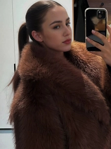 Close-up of luxurious dark brown faux fur coat featuring a thick wide lapel collar