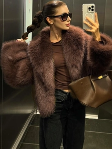 Detail of plush brown faux fur coat showing thick texture and wide lapel collar