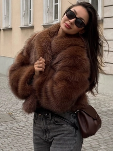 Street style view of a plush brown faux fur cropped jacket with thick texture