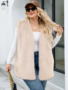 Close-up of fluffy apricot faux fur vest texture on model wearing white long sleeve top