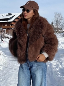 Women's brown faux fur coat with lapels paired with denim pants in snowy outdoor scene