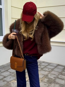 Detailed texture of thick dark brown faux fur jacket with fluffy winter coat fibers