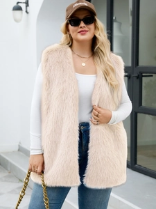 Street style shot of a beige faux fur long vest paired with jeans and a white top