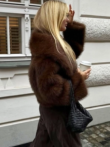 Close-up of thick dark brown faux fur jacket for women with soft texture and glossy finish