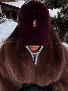 Close-up of deep burgundy corduroy baseball cap with polo rider embroidery in winter
