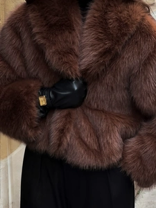 Detailed close-up showing the soft plush texture of dark brown faux fur coat with lapel