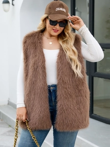 Outdoor shot of brown faux fur vest styled with a white top and blue denim jeans