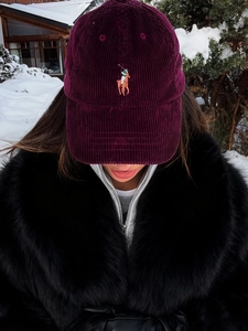 Macro detail of wine red corduroy baseball cap with high-quality polo player embroidery