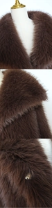 Detailed macro view of dark brown faux fur texture and metal hook closure on the winter coat