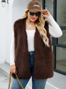 Street style view of a brown faux fur vest paired with a white top and blue jeans