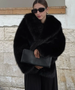 Detail of black faux fur texture on oversized collar coat with soft plush finish