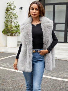 Chic women's grey faux fox fur vest in mid-length style shown in an outdoor setting