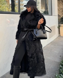 Détail d'un manteau long en fausse fourrure noire avec large ceinture en cuir chic