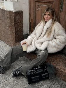 Fashionable oversized off-white faux fur coat with lapels for winter street style