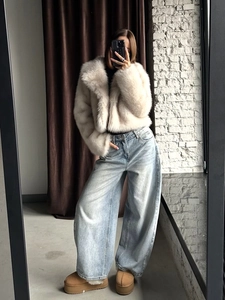 Chic cream faux fox fur short jacket paired with high waist wide leg jeans and snow boots