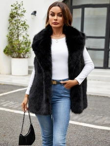 Outdoor shot of a black faux fur vest featuring a large collar and fluffy texture
