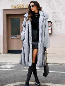 Photo de rue d'une femme portant un long manteau en fausse fourrure gris clair et des bottes