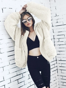 Detail of soft cream sherpa hooded jacket with silver zipper and large pockets