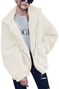 Close-up of beige teddy jacket fabric featuring a front zipper and textured faux shearling