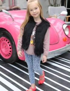 Détail d'un gilet en fausse fourrure noire pour enfants avec un t-shirt graphique en coton