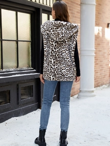 Back view of leopard print faux fur hooded vest shown in a snowy outdoor street scene