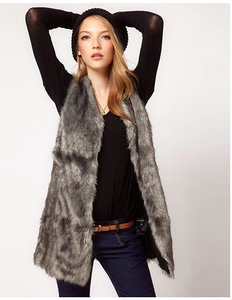Close-up of fluffy grey faux fur vest texture on model wearing black long sleeve top