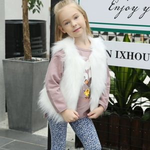 Détail d'un gilet en fausse fourrure blanche assorti à une robe rose fleurie pour fille