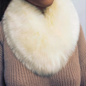 Close-up of fluffy faux fox fur collar in cream white on a brown knit sweater