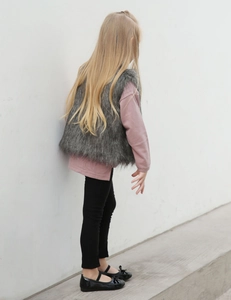 Vue extérieure d'un gilet gris en fausse fourrure pour enfant avec haut rose