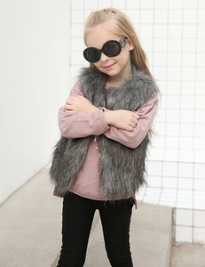 Détail d'un gilet pour enfant en fausse fourrure grise avec une texture douce et moelleuse