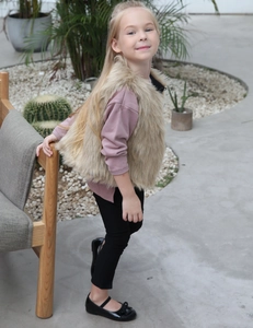 Gilet en fausse fourrure pour enfant kaki clair porté avec haut rose et pantalon noir