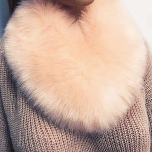 Close-up of soft pink faux fox fur collar texture on a knitted sweater neck