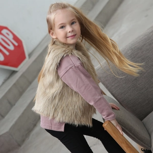 Détail d'un gilet en fausse fourrure marron pour fille avec un haut rose doux