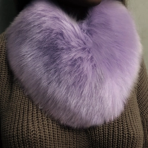 Detail of soft purple faux fur scarf wrap on model wearing a brown knitted sweater