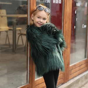 Detail shot of plush dark green faux fur texture on a stylish children's winter coat