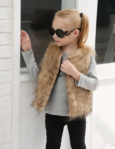 Détail du gilet en fausse fourrure marron avec haut en coton gris et legging noir