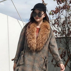 Detail of trendy faux fur collar on a gray plaid mid-length coat for women