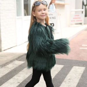 Detailed texture of kids long-hair dark green faux fur coat in stylish street style