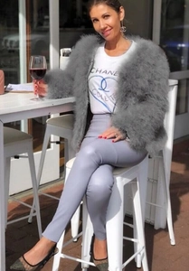 Giacca corta alla moda in piume di struzzo grigie con pantaloni lilla e tacchi alti
