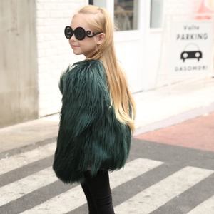 Detail of a dark green faux fur coat for kids with rich texture and shaggy wool finish