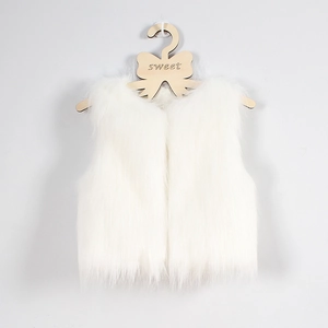 Gros plan sur la texture douce d'un gilet en fausse fourrure blanche pour enfant