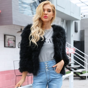 Giacca chic in finta pelliccia di piume di struzzo nera con jeans in denim a vita alta