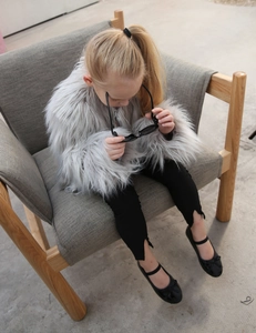 Detailed texture of grey faux fur coat for kids with soft and fluffy material finish