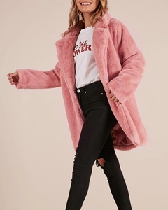 Detail view of pink faux fur coat with lapels paired with a graphic T-shirt and ripped jeans